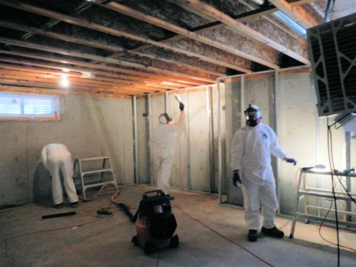 3 hazmat technicians working on basement repairs