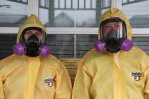 Hazmat Technicians Wearing Yellow Suit And Gas Mask