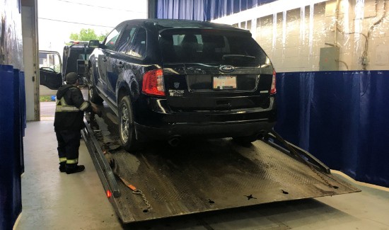 Towed recovered stolen car unloaded at shop