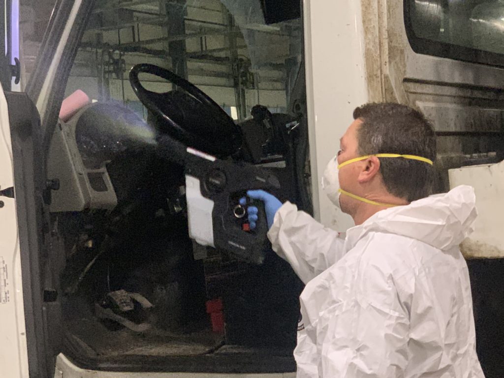 mayken hazmat solutions specialist using disinfectant spray in a vehicle